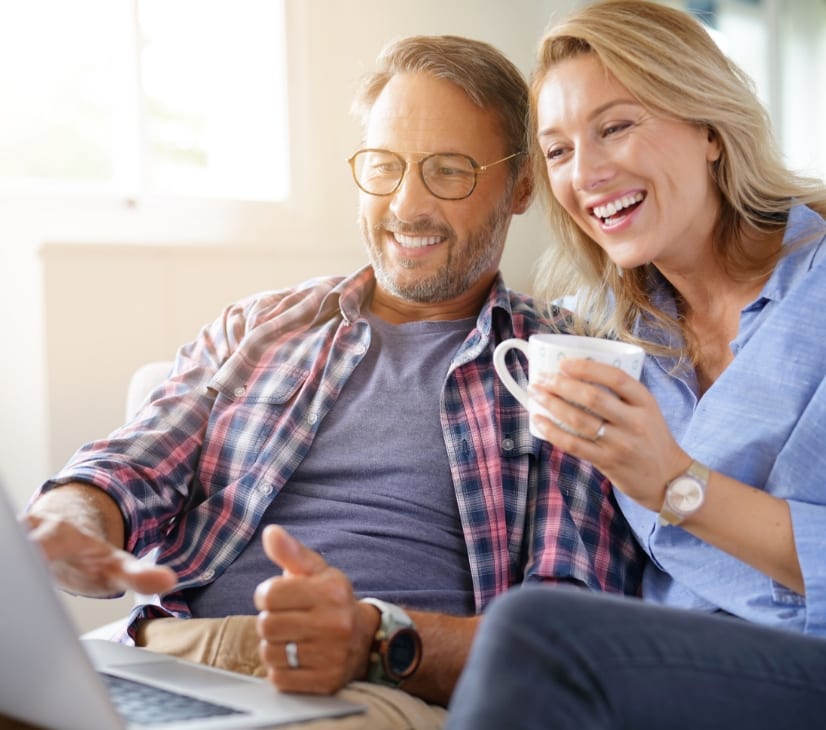 Couple smiling and looking at laptop