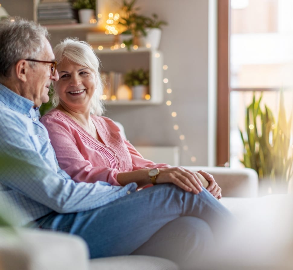 Elderly couple sitting together on a couch