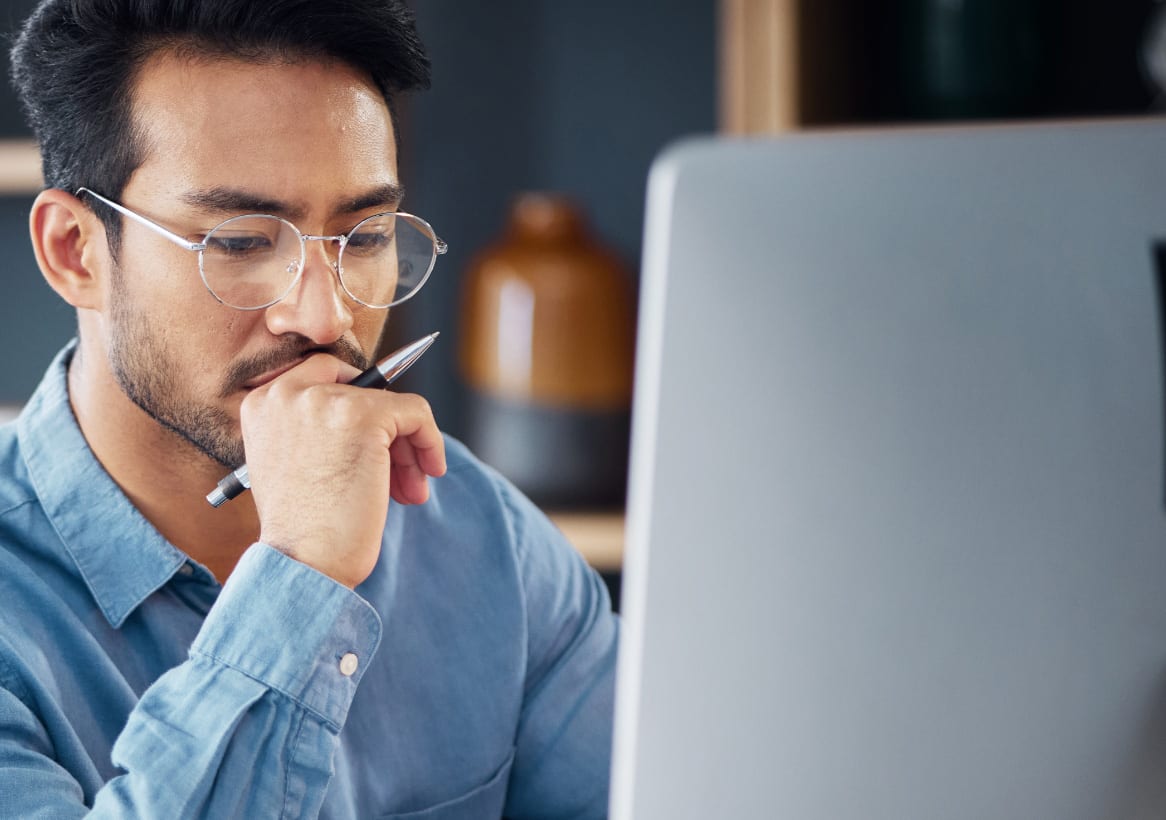 man in thought looking at computer