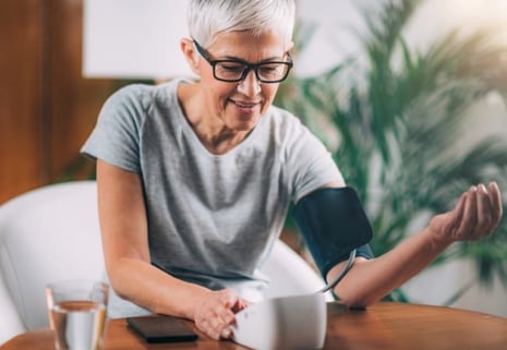 Middle-aged woman taking blood pressure at home